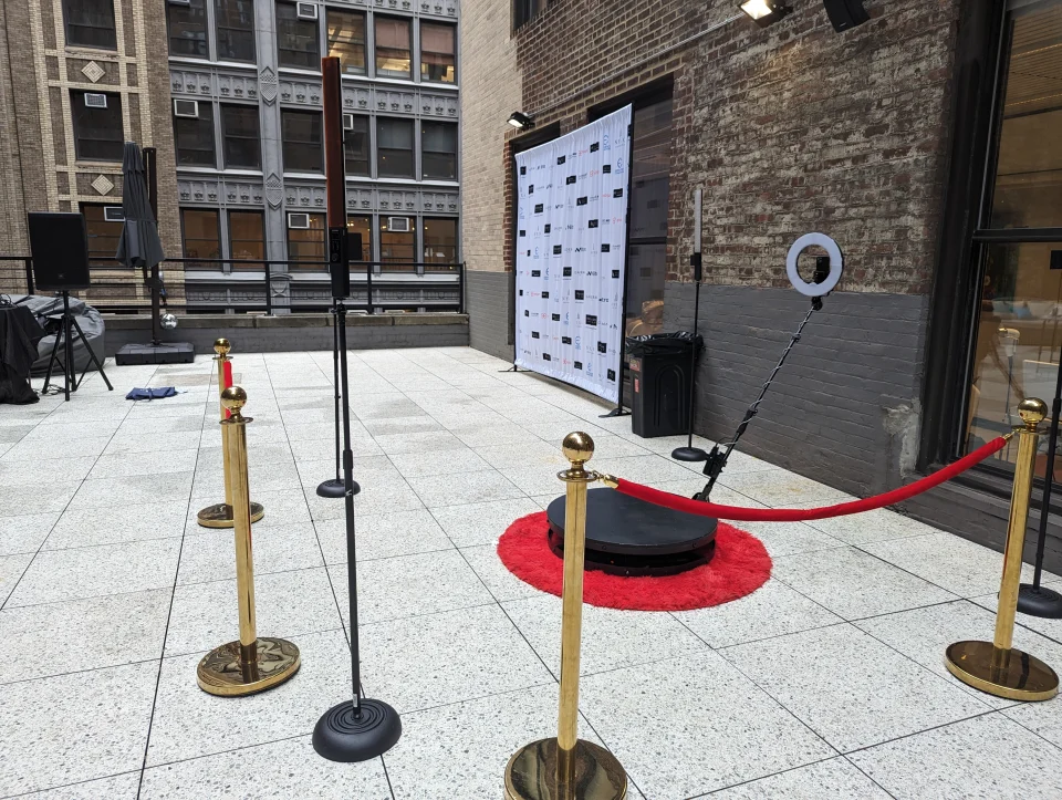 Corporate 360 photo booth setup with red carpet and step-and-repeat backdrop NYC