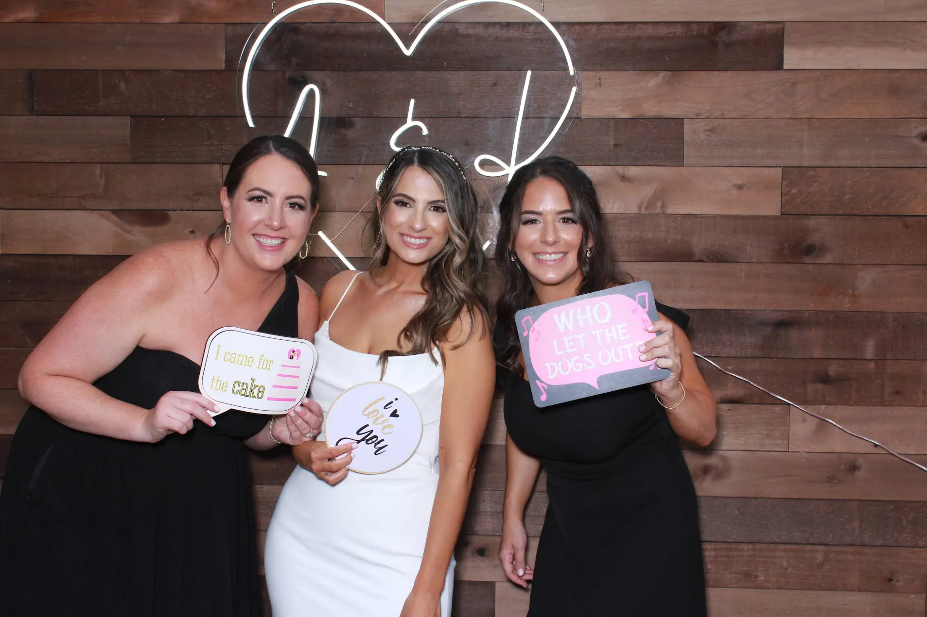 Retro photo booth at wedding with props and neon backdrop